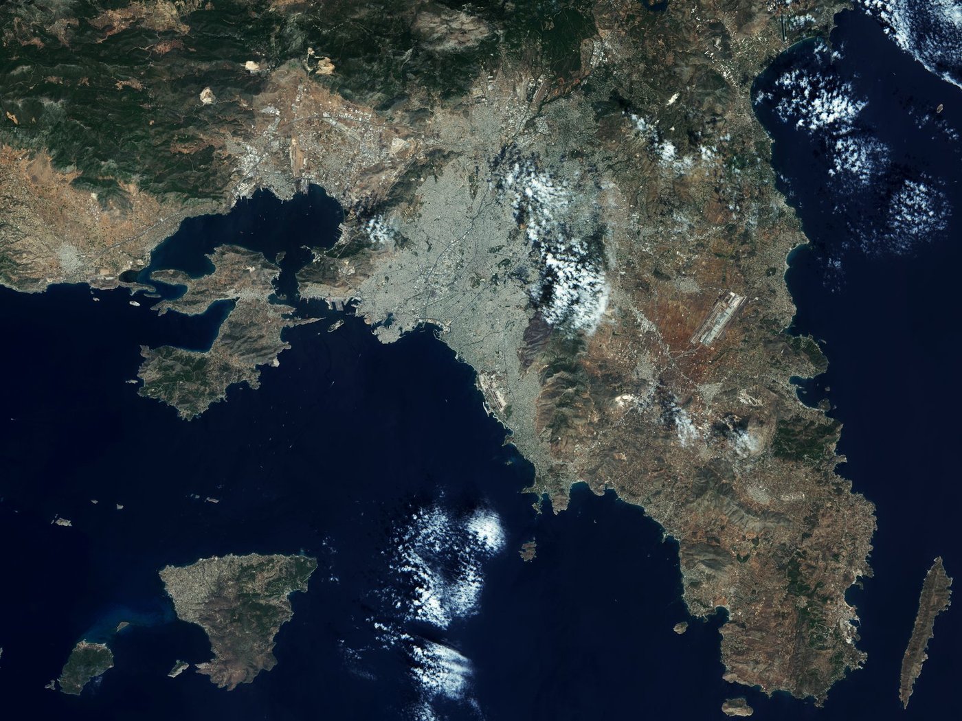 This high-resolution optical image from Sentinel-2A on 5 August 2015 shows Athens and surroundings. The various colours clearly point out different aspects of the image.
The Greek capital dominates the Attica region and is one of the world’s oldest cities, with its recorded history stretching over 3400 years.  It hosts two UNESCO World Heritage Sites, the Acropolis of Athens and the medieval Daphni Monastery.
Home to some 3.5 million people, the city appears greyish, backed by greenish mountains on its eastern edge. Athens International Airport can be seen further east, surrounded by agricultural fields, which are depicted in shades of red. The old airport is also visible along the coast towards the south of the city, now apparently no longer in use.
The ancient Port of Piraeus, southwest of the city centre, is one of the largest seaports in the Mediterranean Sea. It is the largest passenger port in Europe and the third largest in the world. Servicing about 20 million passengers annually, it routes them to Greece’s many islands in the Aegean sea.
The image captures various vessels in the area, waiting to enter or exit the port, visible thanks to the 10 m-resolution on Sentinel-2A’s camera.
In the lower far-right corner of the image we can see the island of Makronisos. It has an elongated shape, 13 km north to south, around 500 m east to west, and its terrain is arid and rocky.
Today, it is uninhabited, but it was used as a prison from the time of the Greek Civil War up until the restoration of democracy in 1974. Because of its history, it is considered as a monument of the civil war era, with the island and the original structures protected from alteration.
Sentinel-2 is a two-satellite optical mission for Europe’s Copernicus programme. The first satellite, Sentinel- 2A, was launched on 23 June 2015. It provides detailed information about Earth’s land cover and inland water bodies, helping us to understand Earth’s diverse landscape. 

This image is featured on the Earth from Space video programme.