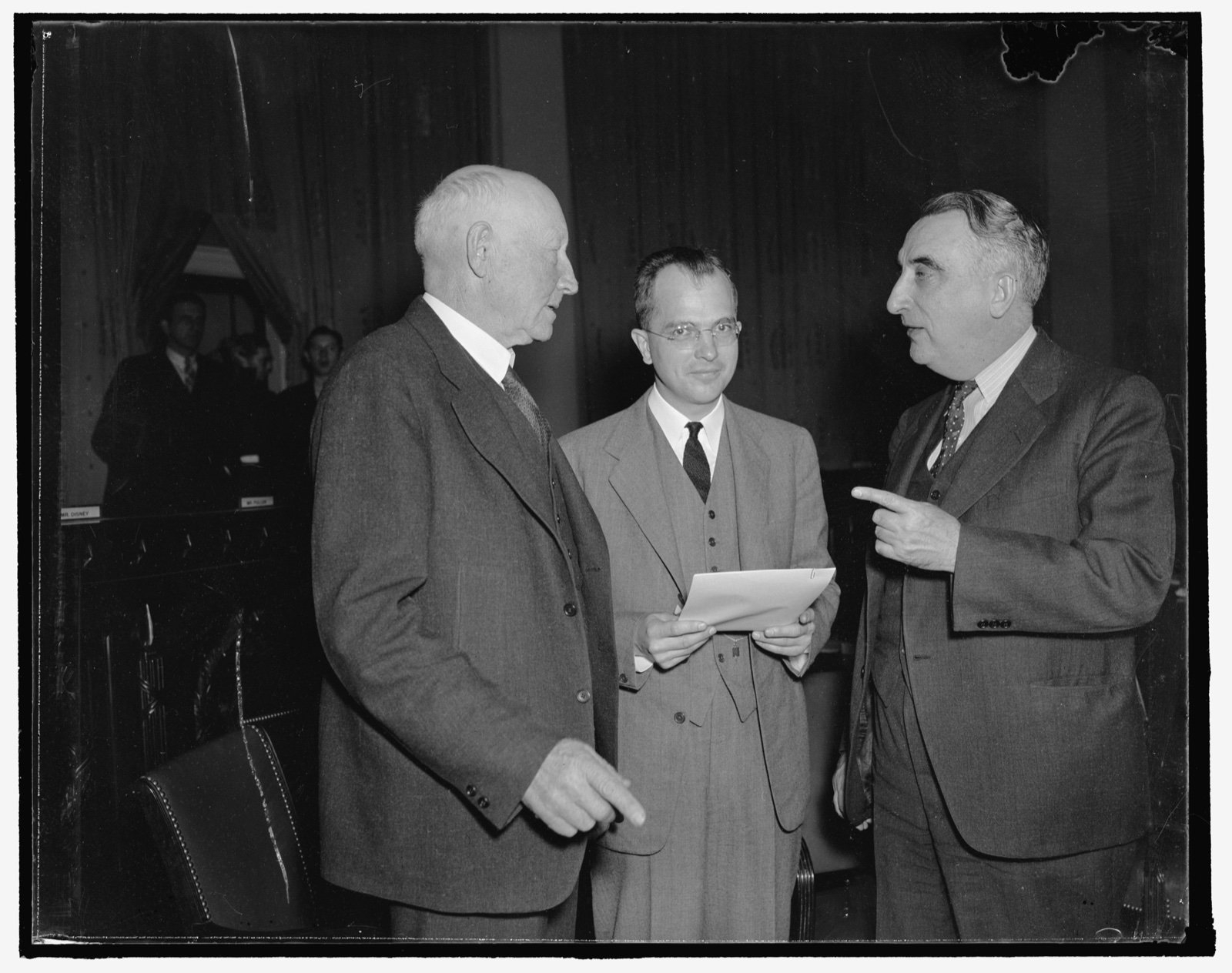 Title: Little fellow pays most of the taxes. Washington, D.C., Nov. 8. The House Ways and Means Sub-Committee learned today that taxpayers in the income bracket from $5,000 to $25,000 a year make most of the Capital gains and pay most of the tax, treasury experts who gave the information also presented a table showing that the Capital gains tax yielded $516,000,000 in 1929 and brought in approximately $85,000,000 last year, photographed at the hearing today were left to right: Cong. Robert Doughton, Chairman of the House Ways and Means Committee; Roswell Magill, Undersecretary of the Treasury; and Cong. Fred Vinson, Chairman of the House Sub-Committee. 11/8/37
Abstract/medium: 1 negative : glass ; 4 x 5 in. or smaller