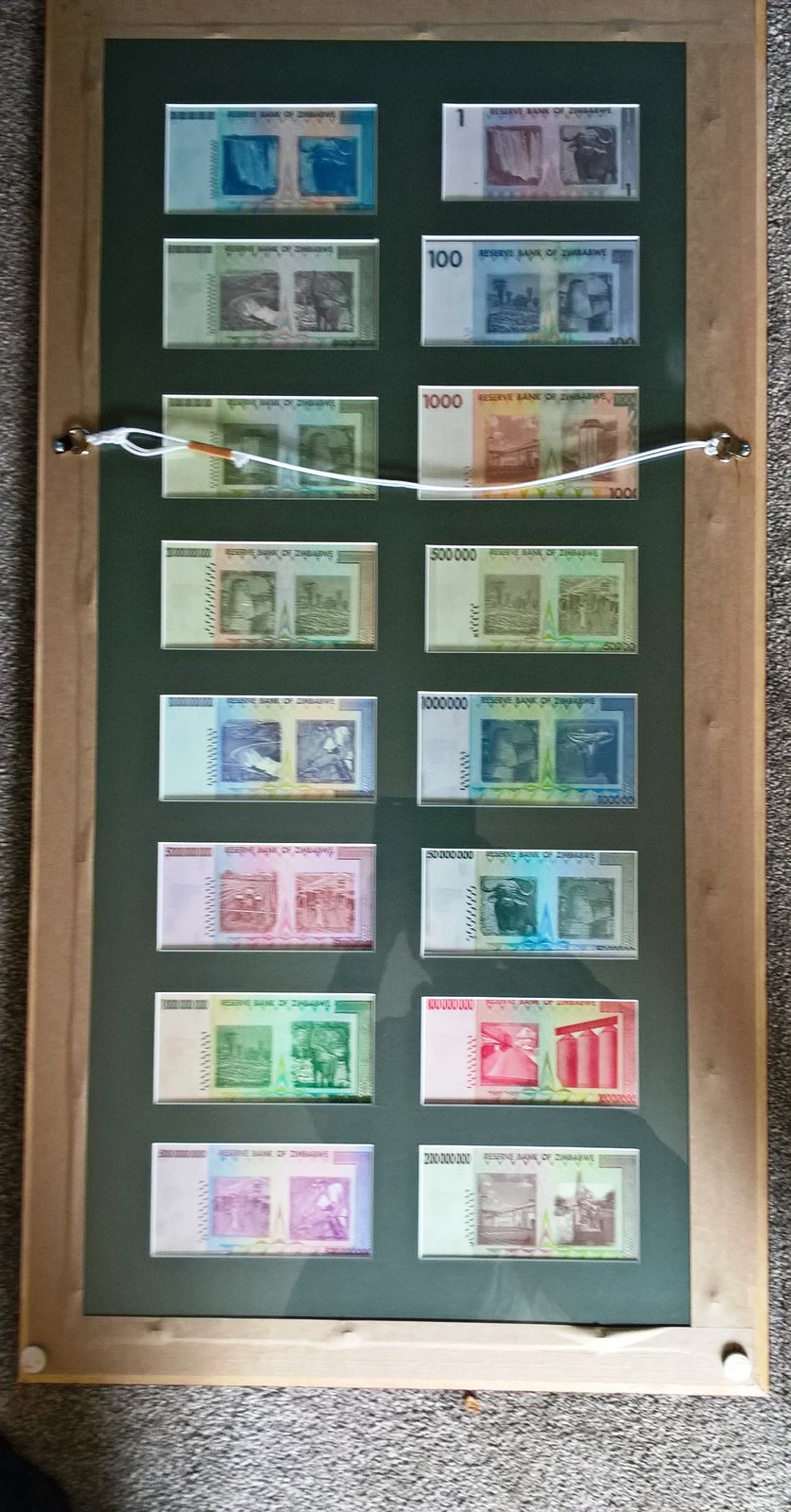 Selection of 16 original un-circulated Zimbabwe notes ranging in denomination from 1 dollar to 100 trillion dollars.  They are all signed by Dr G Gono, the Governor of the Reserve Bank of Zimbabwe, in the period 2007 to 2008, who promises "to pay the bearer on demand".  They are mounted in a frame.
